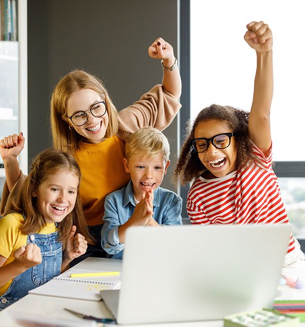 therapist and children cheering while looking at laptop screen